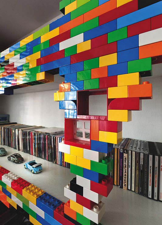 Huge ‘Lego Blocks’ were fixed to wooden bookshelves with 3M tape so the owners could “redesign” the shelves as they prefer.