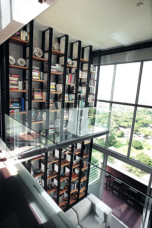 The look of the open shelving is unhindered by staircases or ladders – instead, a glass walkway provides access to the higher shelves.