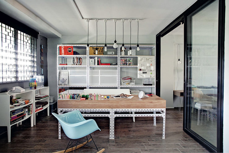 A reproduction Eames rocker adds a shot of pale blue to the wood-and-white study. The homeowner custom-built her industrial-style desk and shelves.
