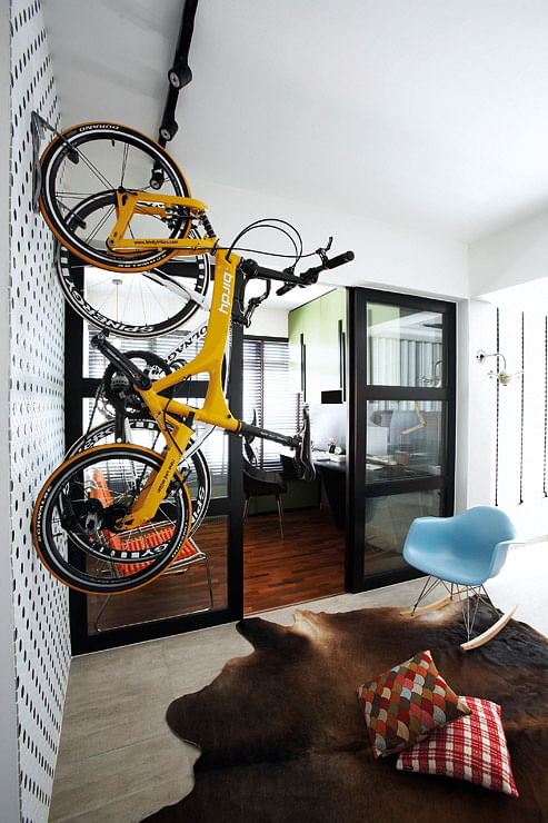Wall mounted bicycle racks for road bicycles in this Mid-century, retro and industrial styles complete one another in the living room. Interior design by Fuse Concept.