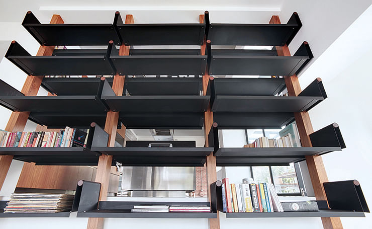 To improve air flow, the designer replaced the wall between the living room and kitchen with these open shelves.