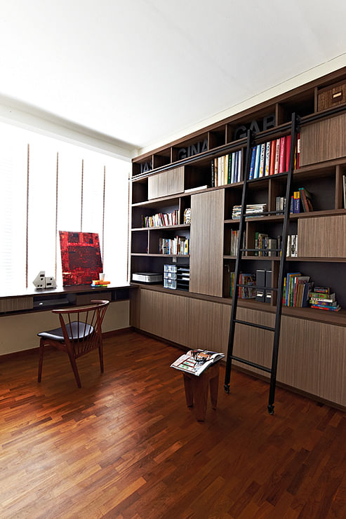 Custom-built floor-to-ceiling shelves and a stepladder create a classic library look for the study.