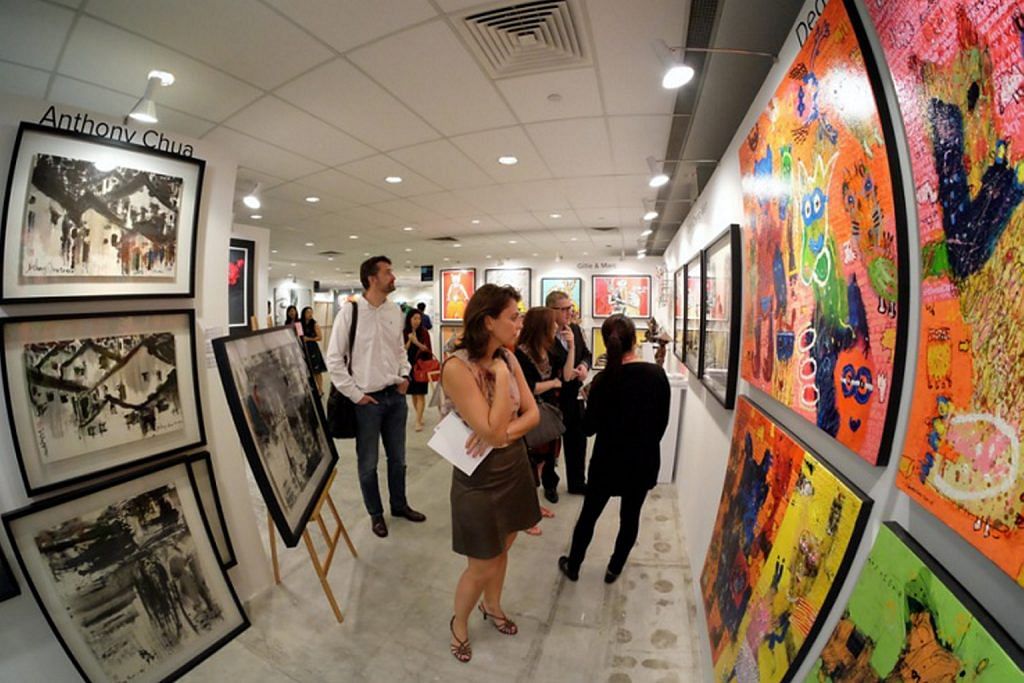 Patrons viewing displayed art mounted on walls at the Affordable Art Fair in Singapore in 2016.