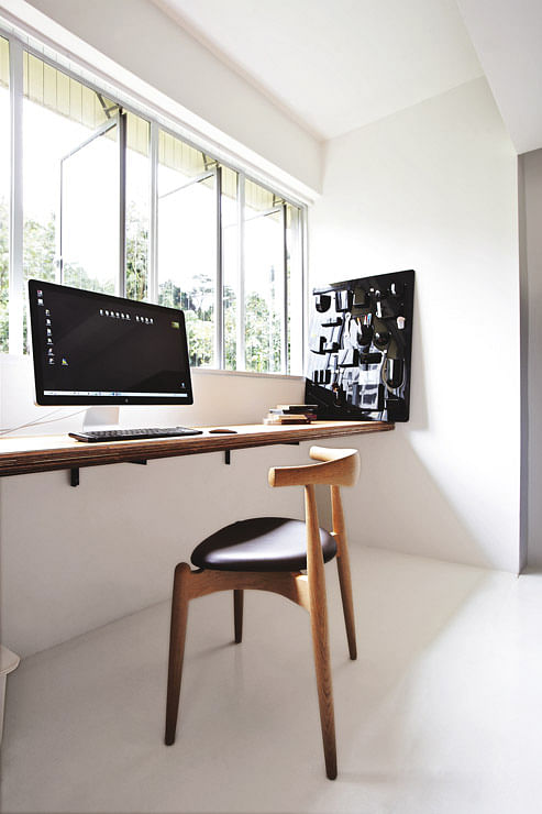 After hours of working at his workbench, Desmond just needs to look up and enjoy a relaxing view. A Hans Wegner Elbow Chair is a worthy investment. 