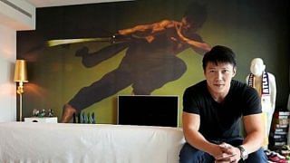 Vincent Ng in front of a wallpaper of himself in his living room. He describes the style of his home as minimalist, modern and relaxed. Photo: The New Paper