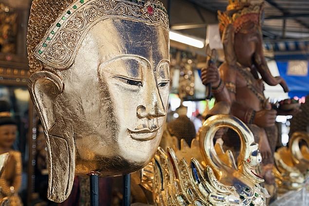 Gold tone Buddha statue sculpture at the Chatuchak market on display.