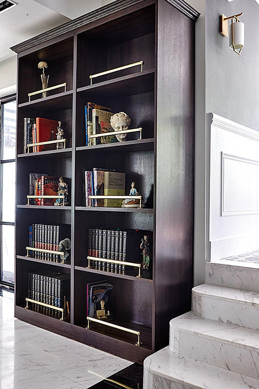 Gold handles give this bookshelf an Art Deco look. This bookcase also conceals the store room entrance. Design: Museum Homes
