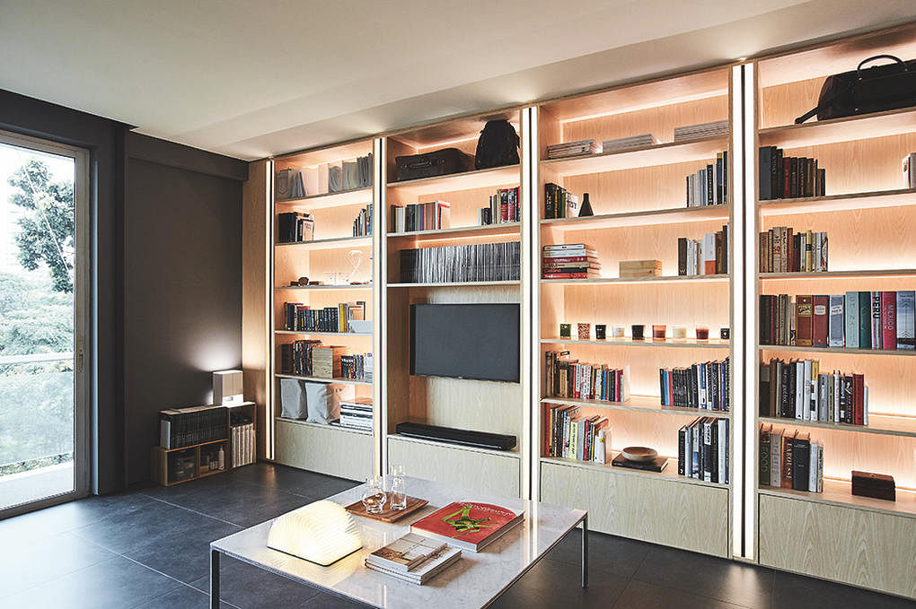 When designing your customised bookshelf, include ambient lighting for a cosy living room. Design: Architology