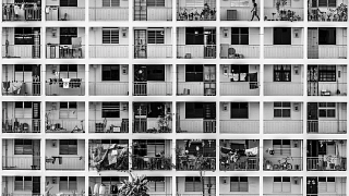 Black and white frontal view of an old HDB building with shoebox units in Singapore.
