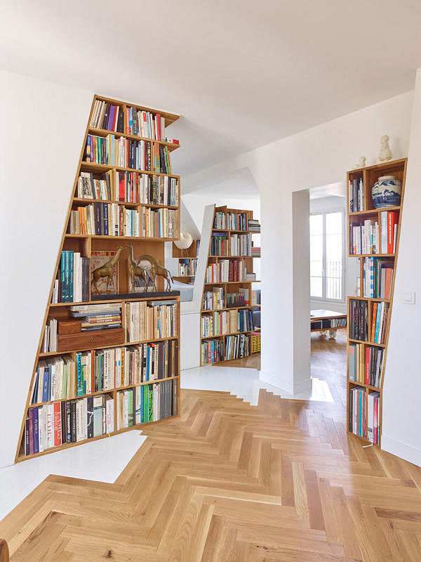 This Parisian flat was designed to include five bookcases, big and small, which separate three living spaces. Design by h2o architectes