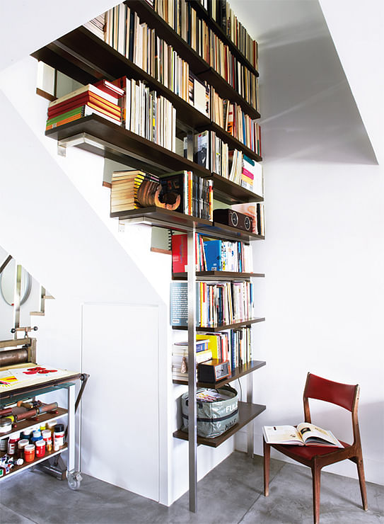 Instead of installing a railing, a bookshelf was built on one side of this staircase.