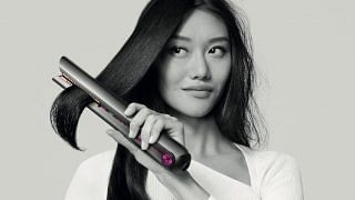 Female model using the Dyson Corrale Hair straightener