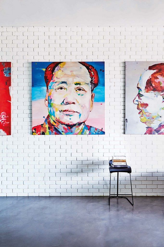 A series of three pop art works hung on a wall of exposed white bricks in a home in Singapore. Interior design by Architology.