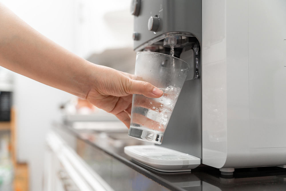 https://media.homeanddecor.com.sg/public/2023/03/close-up-hand-woman-drinking-water-is-poured-from-water-cooler-into-glass-drinking-water-machine.jpg