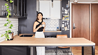 Homeowner Ingrid Liew enjoying a cuppa in her chic industrial-style open kitchen.