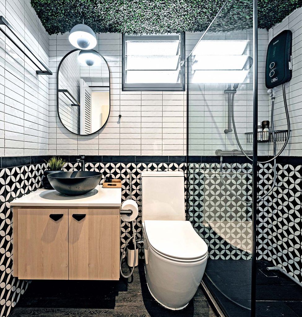 Bathroom with black and white contrast tiles and artificial plants.